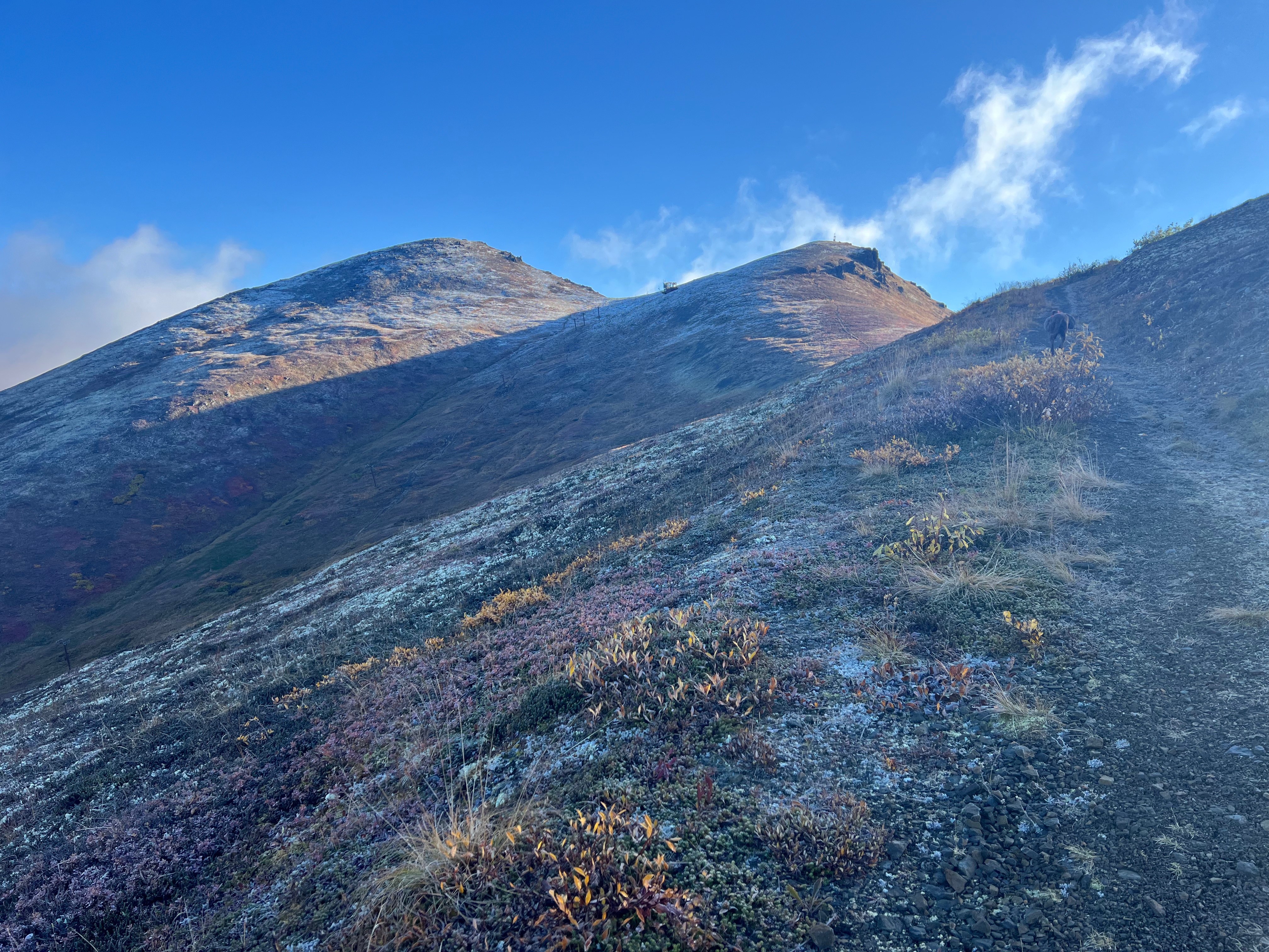 Facing up the ridge to two peaks. A ski lift runs up the slope to the peak on the right.