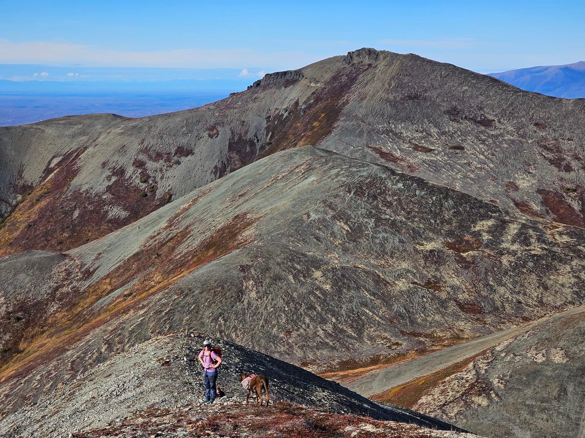 The author and her dog taking a break during a climb. Ridgeline and Lazy Mtn peak visible in the background.