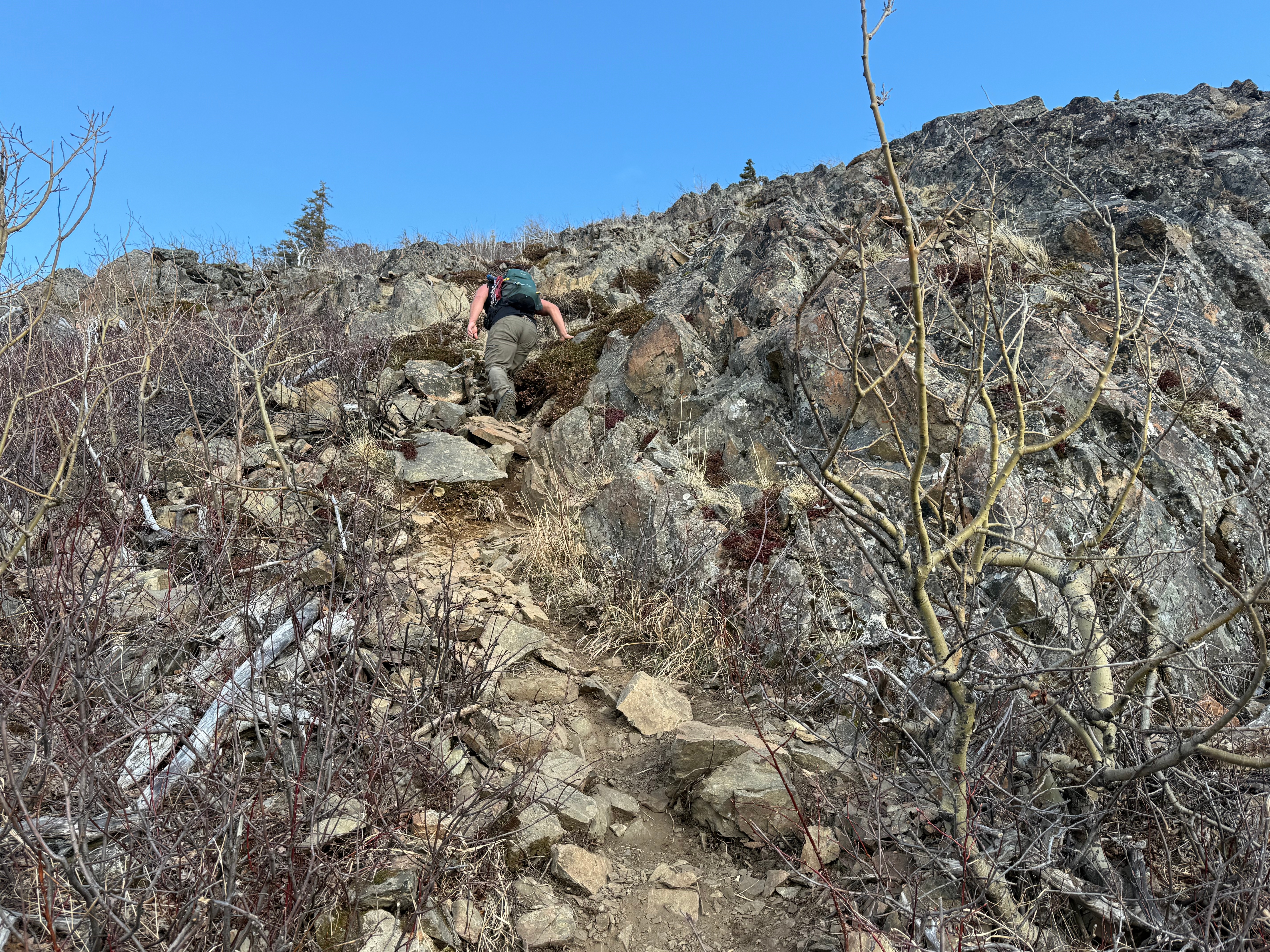 A hiker negotiates a steep, rocky path.