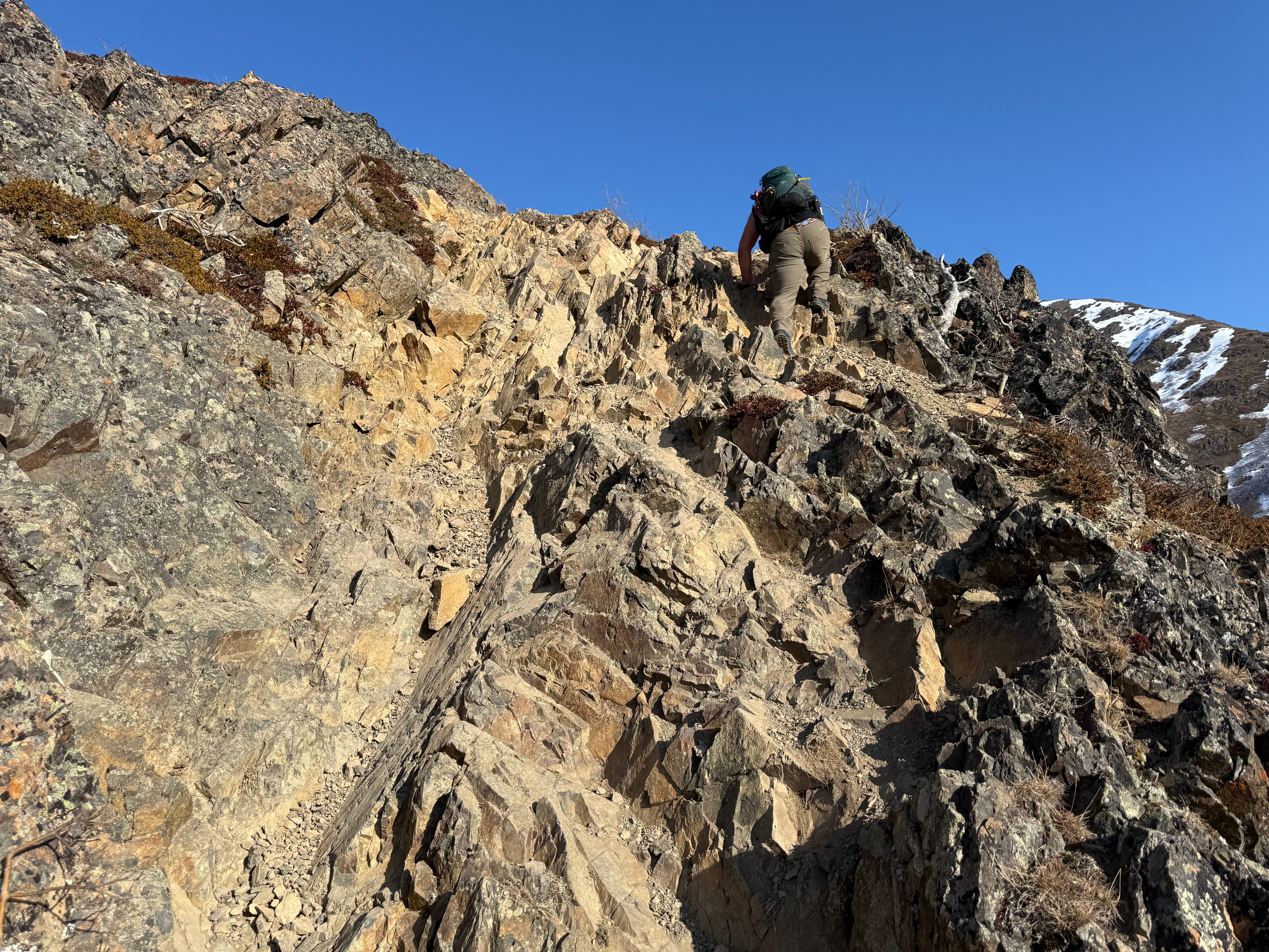 A hiker negotiates a steep, rocky path.