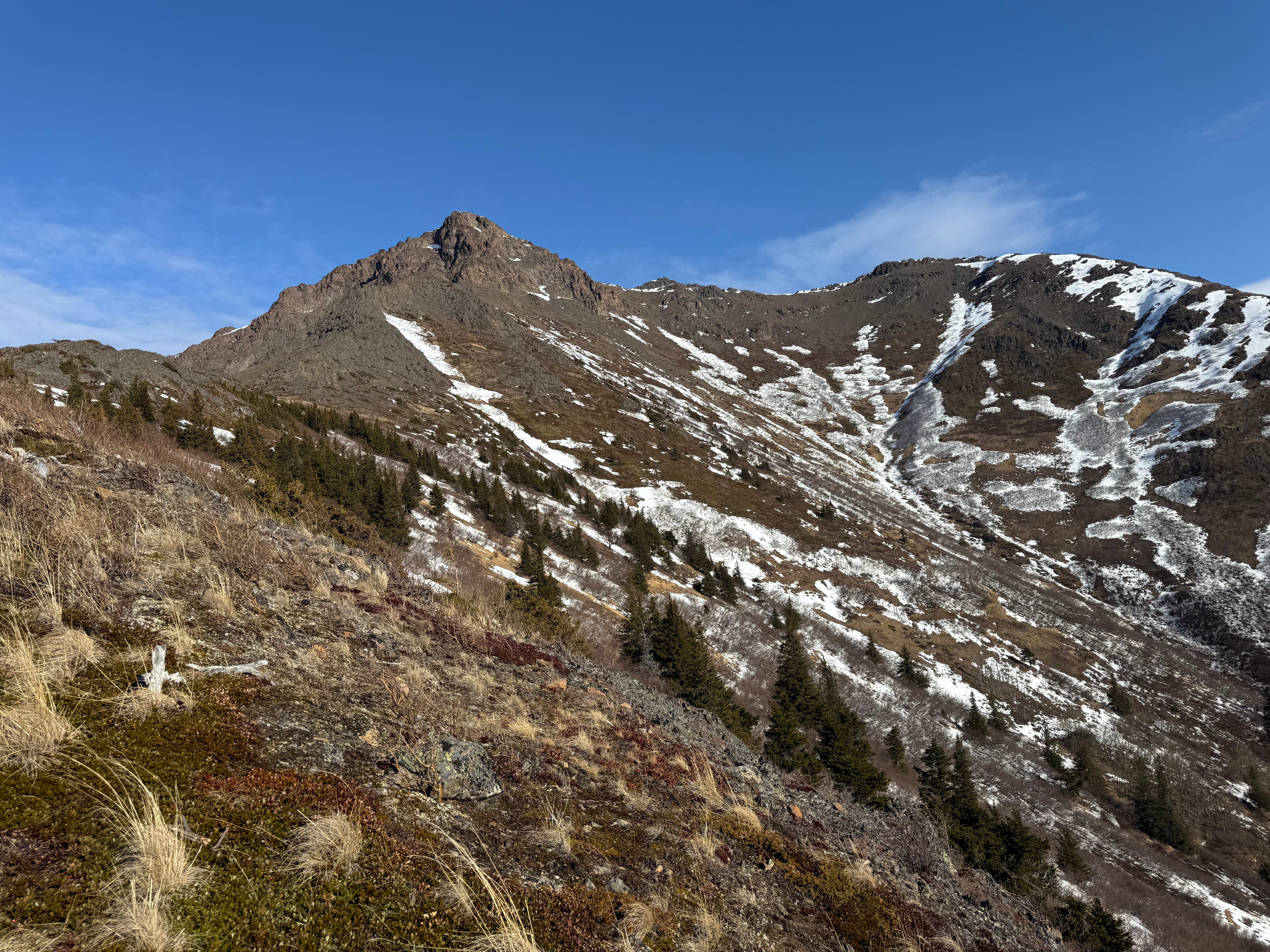 A rocky summit rises up from a valley
