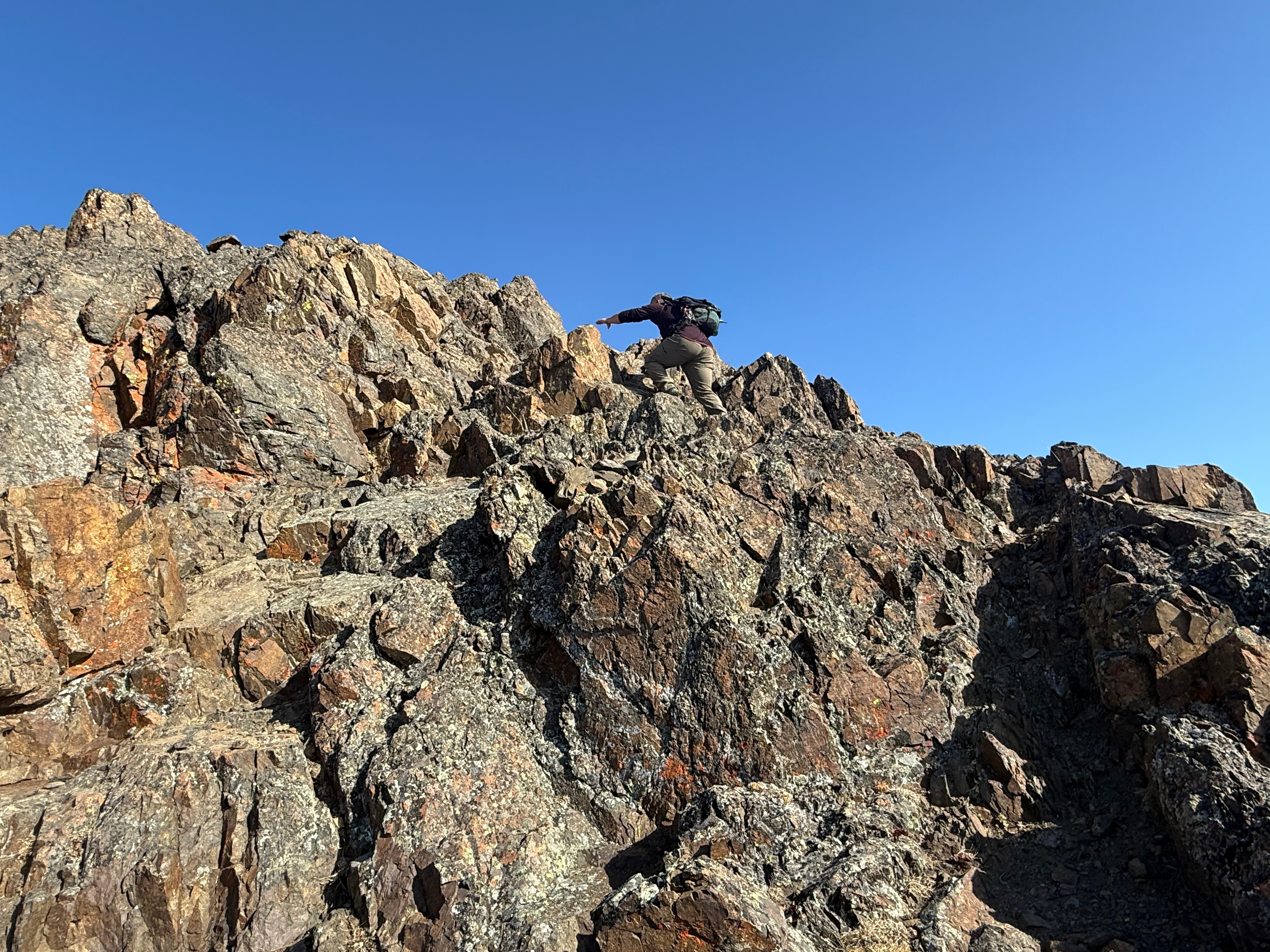 A hiker negotiates a steep, rocky section of trail.