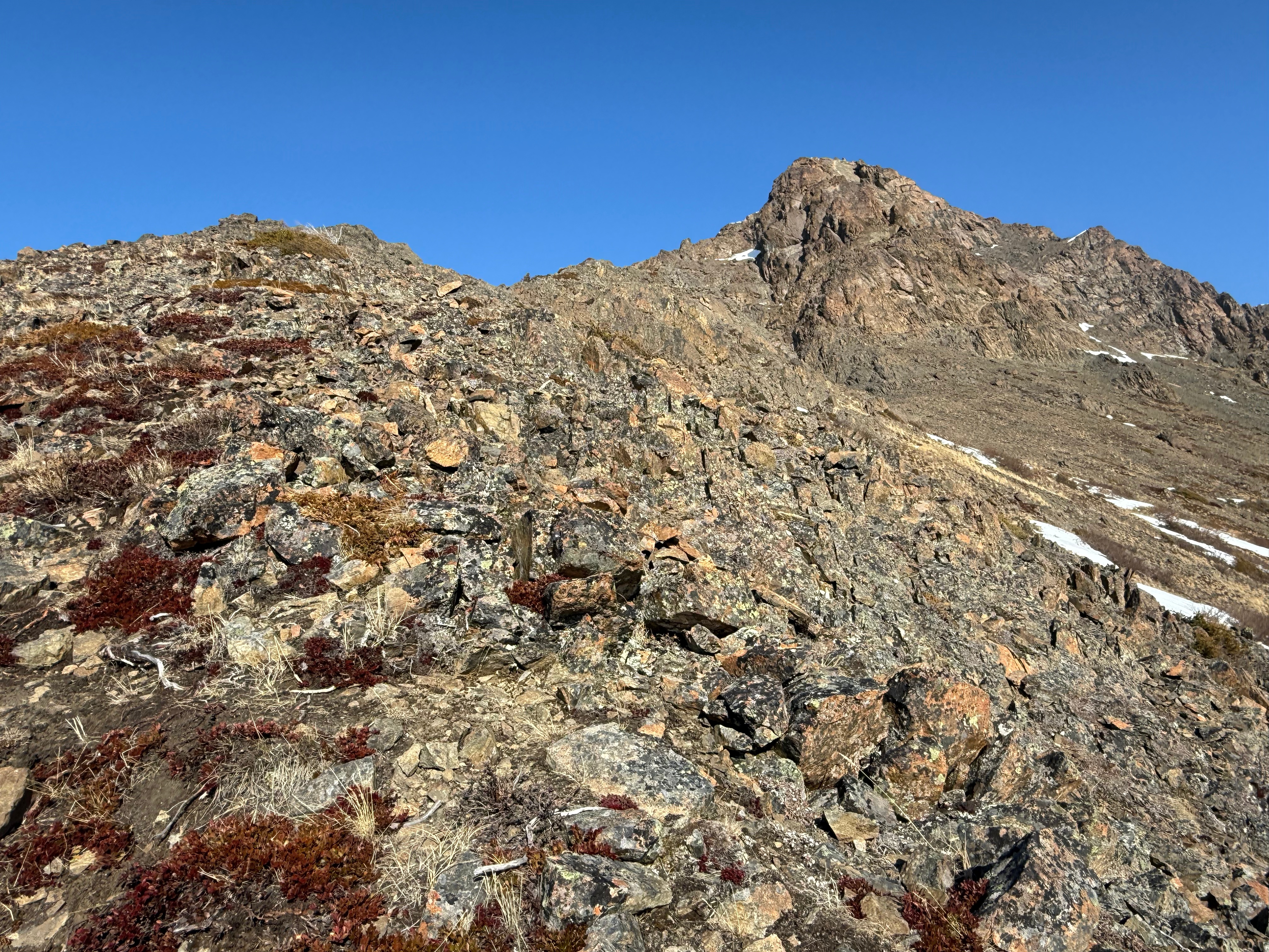 The rocky summit rises above scree slopes