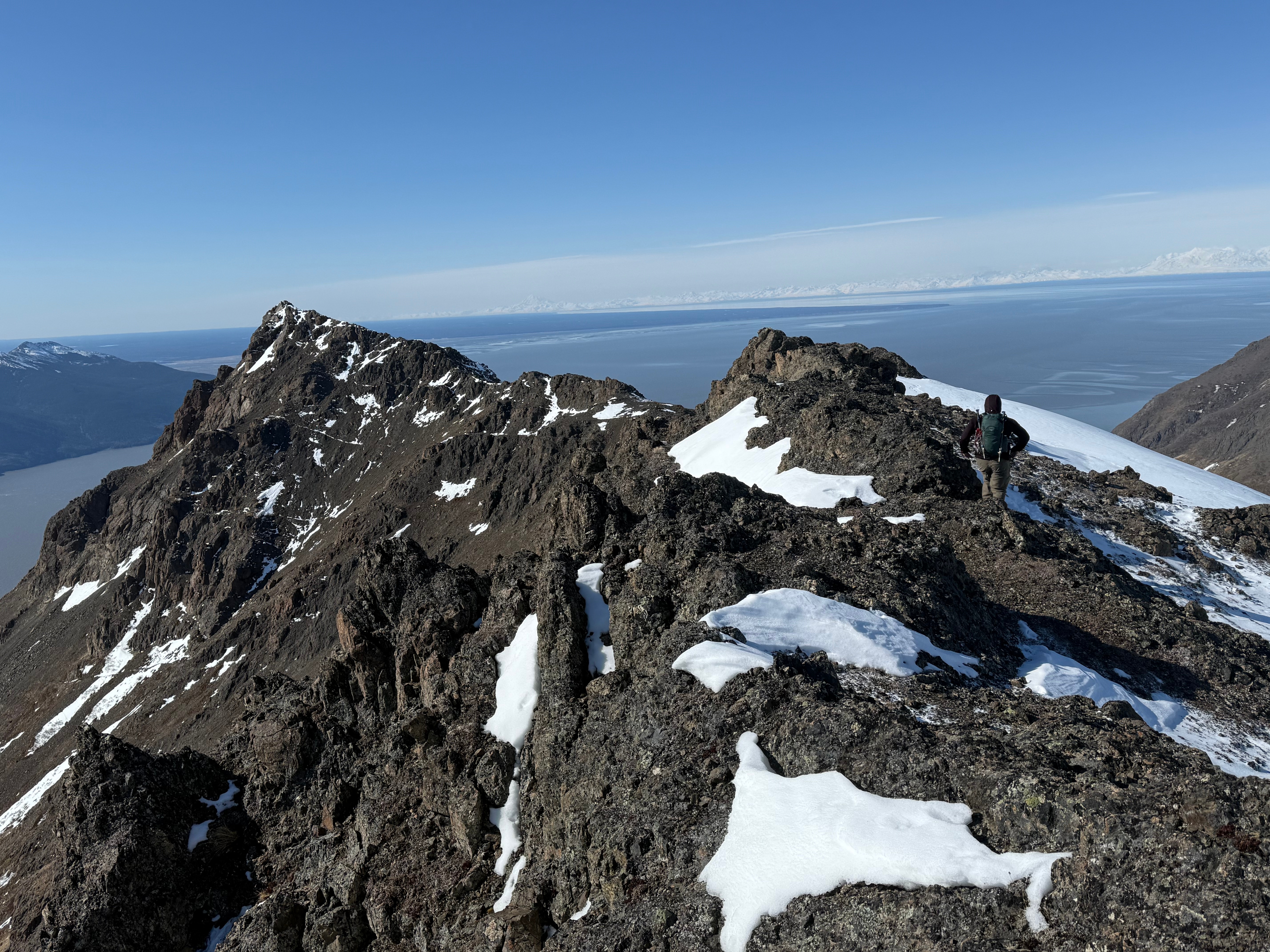 A hiker walks back towards Rainbow Peak on the rocky ridge