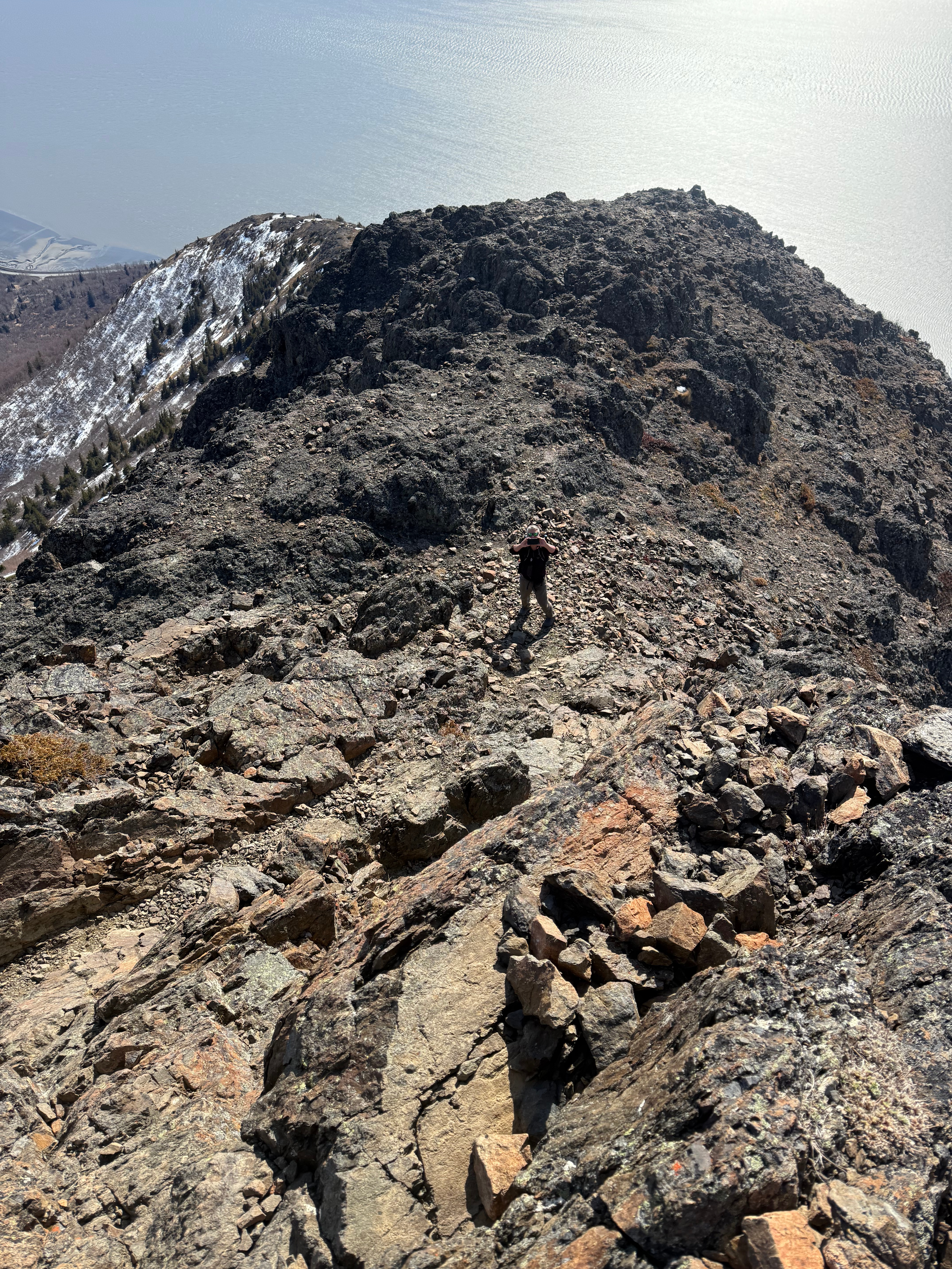 A hiker takes a picture from the bottom of a steep, rocky step.