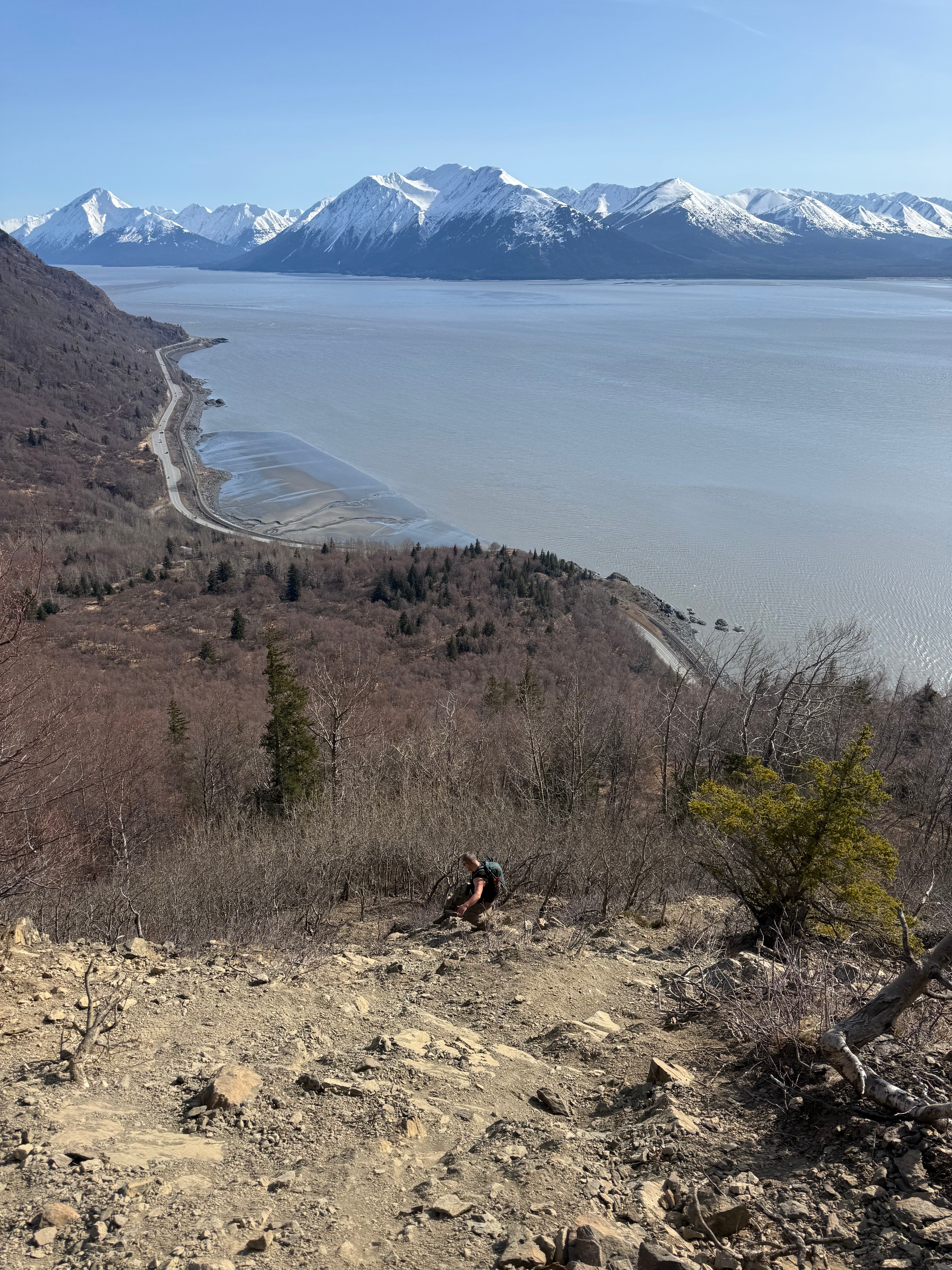 A hiker navigates an extremely steep slope.