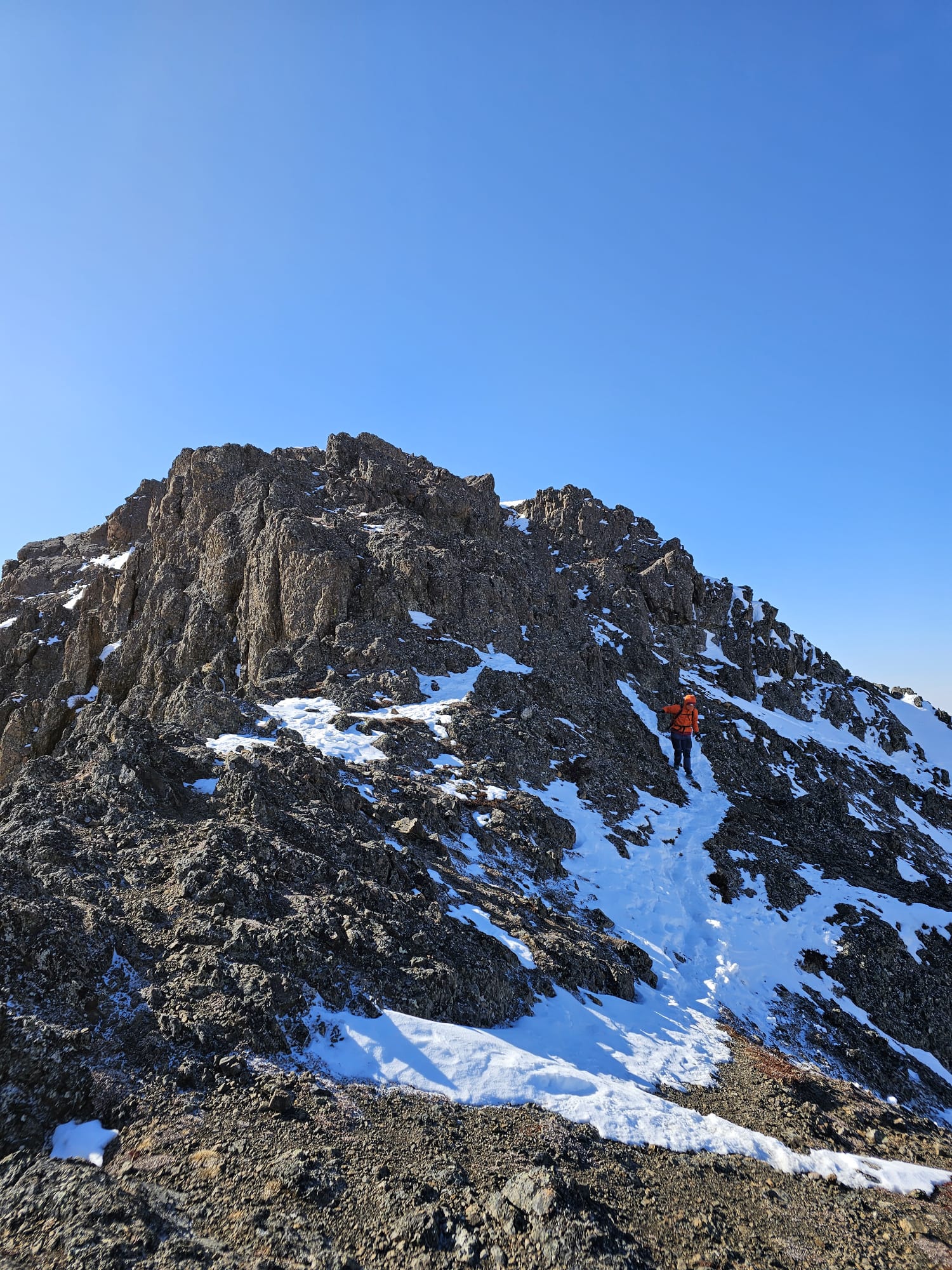 The author descending from the snowy and rocky summit of Rainbow Peak